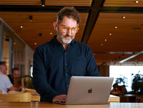 Un membre de l’équipe Apple Fonctions Corporate utilise un MacBook au Caffè Macs.