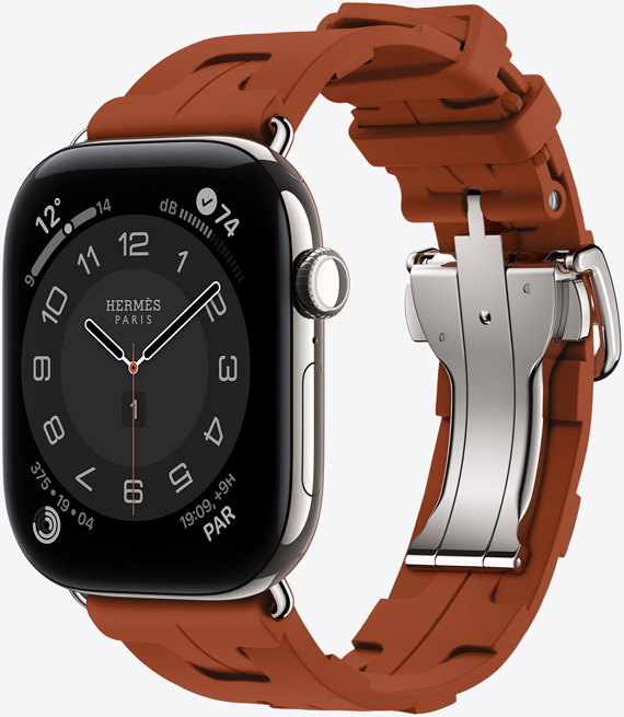 Apple Watch Hermès Series 12, esfera analógica Circulaire, (aguja horaria, minutero y segundero, complicaciones: Tiempo, Ruido, anillos de Actividad y hora de París), caja de titanio, color plata, lateral derecho, Digital Crown, botón lateral, con la correa Simple Tour Kilim, color Cuivre (marrón), fabricada en goma moldeada, diseño geométrico entrelazado, cierre metálico plateado