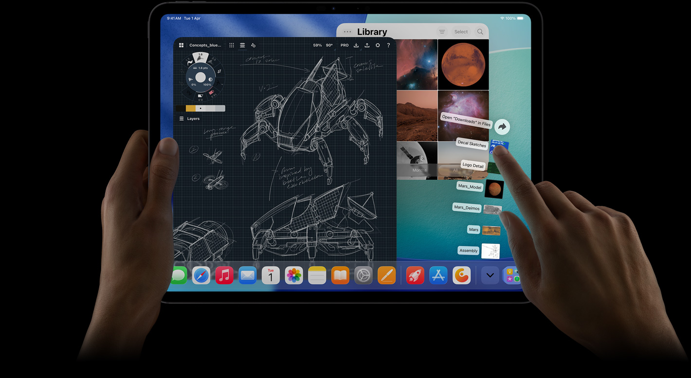 iPad Pro, front exterior, landscape orientation, right hand gesturing over Downloads folder files fanned out, display showing iPadOS interface with multiple open apps including photo editing app with detailed robot blueprints and handwritten annotations and multiple design stages, and Photos Library