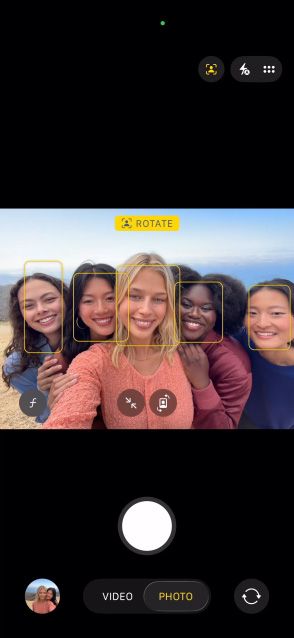 Ecranul modelului iPhone 17 Pro prezentând funcția Scena centrală pentru fotografii și cum să faci selfie cu un grup de persoane, cu fețele acestora evidențiate