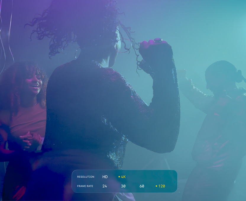 Un ecran ce prezintă oameni care dansează în condiții de filmare cu lumină scăzută demonstrează capacitățile 4K la 120 fps cu Dolby Vision